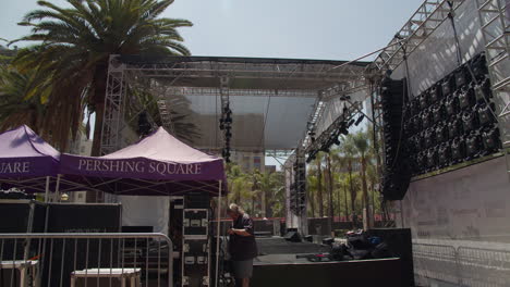 Audio-engineer-setting-up-gear-backstage-before-concert-at-Pershing-Square-in-Los-Angeles