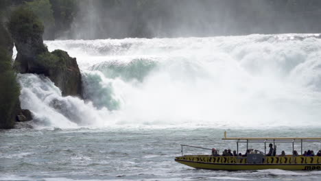 A-boat-with-tourists-watching-the-biggest-waterfall-in-switzerland