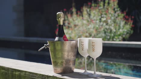 Champagnerflasche-In-Einem-Kalten-Eiskübel-Und-2-Plastikbecher-Draußen-An-Der-Terrassenwand