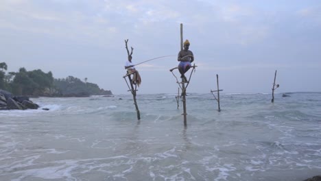 Sri-Lankan-Stilt-Fishermen-Sitting-And-Fishing-On-The-Ocean-In-Weligama,-Matara,-Sri-Lanka