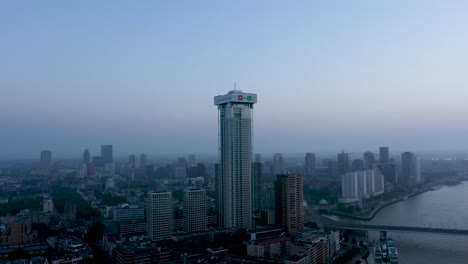 Luftaufnahme-Des-Modernen-Business-Tower-In-Der-Stadt-Rotterdam-An-Einem-Bewölkten-Tag-In-Der-Nähe-Des-Flusses,-Niederlande