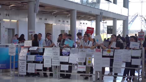 People-with-name-tags-waiting-for-their-guests-on-airport