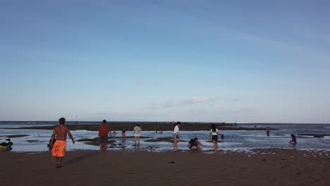 Indonesier-Entspannen-Sich-Am-Strand-Bei-Ebbe-In-Sanur,-Den-Bali-Skyline-Inseln-Und-Der-Natürlichen-Atmosphäre