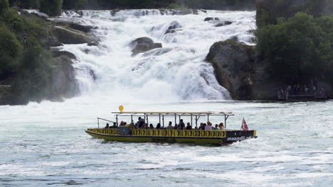 A-boat-with-tourists-watching-the-biggest-waterfall-in-switzerland