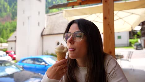 Closeup-portrait-of-woman-enjoying-eating-ice-cream-in-Italian-exterior-bar