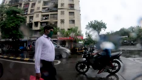 Hombre-Indio-Con-Máscara-Caminando-Por-La-Calle-Bajo-Una-Lluvia-Ligera-En-Mumbai,-India