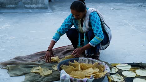 Indian-woman-collecting-dried-papadam-in-her-bucket