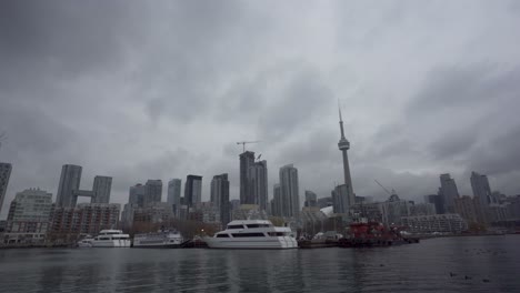 Yachts-in-water-in-foreground-of-Toronto-skyline-on-cloudy-day,-static