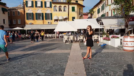Woman-posing-for-a-picture-in-Sirmione-in-Lake-Garda,-Northern-Italy,-on-a-sunny-afternoon-in-September