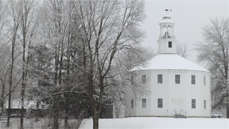 Medium-shot-as-wet-snow-falls-in-winter-at-The-Old-Round-Church-in-Richmond,-Vermont