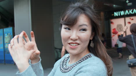 Asian-woman-expressing-with-her-hands-in-a-shopping-district-in-Japan