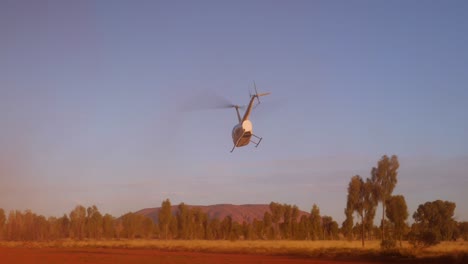 Helicopter-ride,-Ayers-Rock,-Uluru,-takeoff-from-red-sand-desert