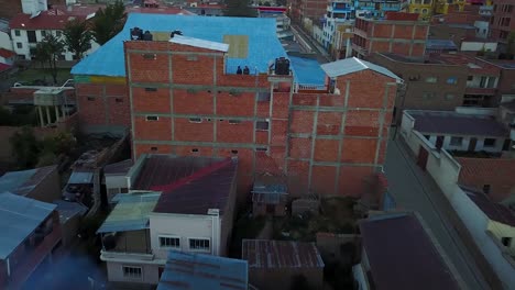 Drone-Aéreo-Disparado-Desde-La-Gente-En-Un-Edificio,-Revelando-La-Ciudad-De-Copacabana,-En-Las-Montañas-De-Los-Andes,-En-Un-Día-Soleado,-En-La-Orilla-Del-Lago-Titicaca,-En-Bolivia,-Sudamérica