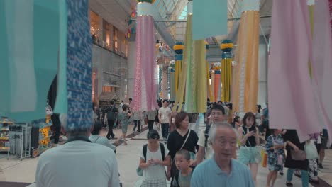 People-on-busy-street-walking-through-decorative-paper-streamers-during-Tanabata-festival-in-slow-motion