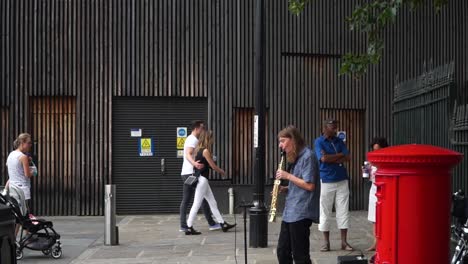 Mann-Spielt-Saxophon-In-Der-Londoner-Straße-Neben-Der-Berühmten-Telefonzelle