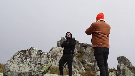 Hombre-Tomando-Una-Fotografía-De-Su-Amigo-En-La-Cima-De-Una-Montaña-En-El-Parque-Nacional-Serra-Da-Estrela-En-Un-Día-Frío-Y-Brumoso