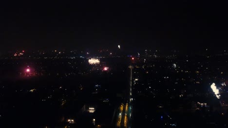 A-smooth-and-aesthetically-drone-flight,-showing-amazing-fireworks-exploding-at-the-horizon-at-New-Year´s-Eve