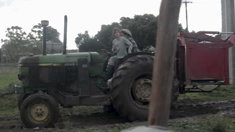 Farmer-and-boy-on-a-green-tractor-on-a-South-American-farm