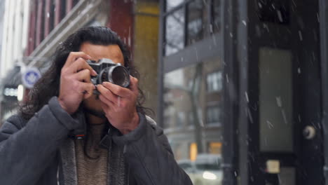 Un-Fotógrafo-Se-Detiene-Para-Tomar-Una-Fotografía-De-La-Arquitectura-Del-Centro-Durante-Un-Frío-Día-De-Nieve