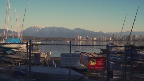 A-LEFT-TO-RIGHT-DOLLY-SHOT-of-Boats-Parked-Behind-a-Fence-at-Kitsilano-Yacht-Club,-the-Warm-Morning-Sun-Lights-the-Scene
