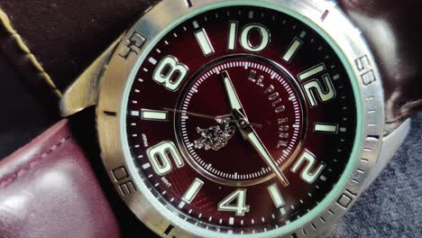Close-up-panning-shot-of-a-Men's-leather-casual-wrist-watch,-having-dark-brown-belt-and-dial-and-stainless-steel-lug-frame