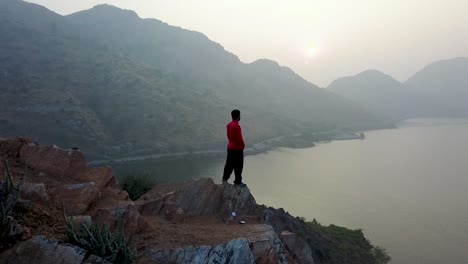 Junger-Mann-Steht-An-Einem-Nebligen-Morgen-Am-Rand-Einer-Klippe-Am-Badi-See-In-Udaipur,-Rajasthan,-Indien