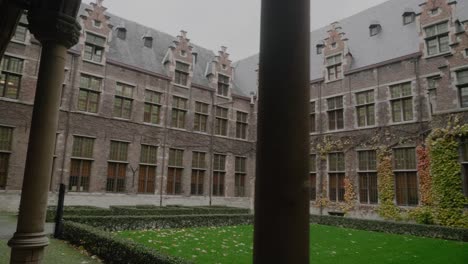 Antwerp-University-Courtyard-Garden,-Ornate-Old-Building,-Pillars-Daytime
