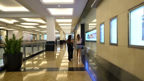 Ladies-Walking-On-The-Concourse-Inside-A-Shopping-Mall-In-Dubai,-United-Arab-Emirates---wide-shot