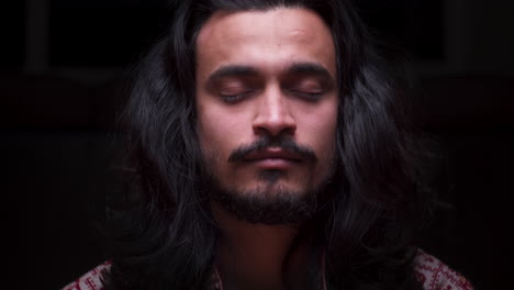 A-SLOW-DOLLY-CLOSEUP-SHOT-of-an-Attractive-Indian-Man-Coming-into-Focus-as-He-Closes-His-Eyes-to-Begin-Meditation