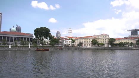 Una-Vista-Del-Río-Singapur-Desde-El-Muelle-De-Barcos-Por-La-Tarde,-Cielo-Azul-Claro,-Crucero-En-Barco,-Cámara-Panorámica-De-Izquierda-A-Derecha