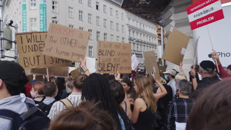 A-shot-of-a-dense-angry-crowd-consisting-of-young-people-holding-signs-and-protesting-against-racism-in-Vienna
