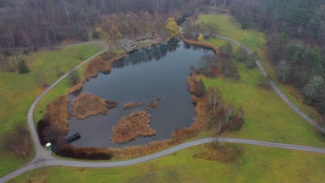 Aerial-footage-over-a-pond-located-in-a-nature-park-beside-Stockholm-University