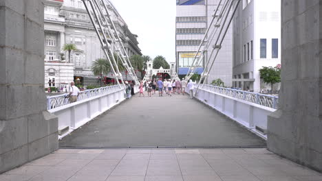 Menschen-Machen-Einen-Spaziergang-über-Den-Singapore-River-Auf-Der-Cavenagh-Bridge-Am-Raffles-Place,-Der-Das-Museum-Der-Asiatischen-Zivilisation-Und-Das-Geschäftsviertel-Raffles-Place-Verbindet