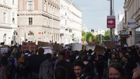 A-shot-of-a-dense-crowd-walking-down-a-street-in-Vienna-while-protesting-against-racism