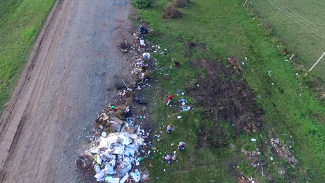 Children-scavenge-through-rubbish-from-a-roadside-landfill,-aerial-view
