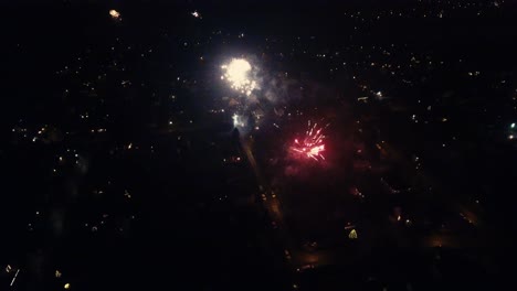 A-very-aesthetic-drone-shot-at-night-of-breathtaking-fireworks,-which-explode-colorfully-and-impressively-in-the-night-sky