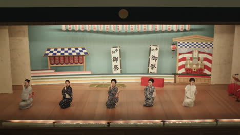 Japanische-Frauen-Führen-Einen-Tanz-Mit-Fächer-Auf-Und-Verbeugen-Sich-Auf-Einer-Bühne