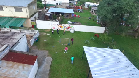 Children-playing-in-a-poor-neighborhood,-aerial-shot-slow-motion
