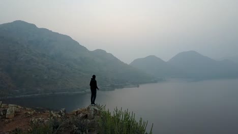 Hombre-Disfrutando-De-La-Vista-De-Una-Mañana-Brumosa-Sobre-El-Lago-Badi-En-Udaipur,-Rajasthan,-India