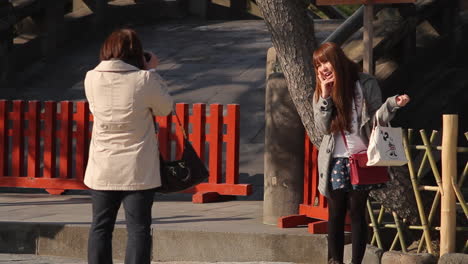 Female-taking-a-photograph-of-tourist-in-Kamakura,-Japan