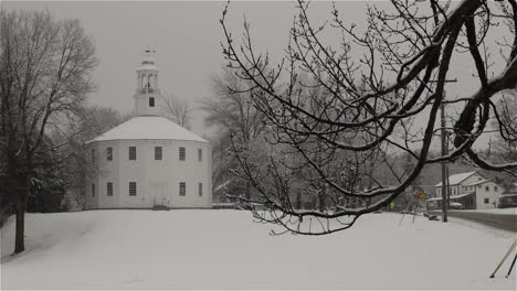 Static-shot-of-wet-snow-falling-on-the-trees-and-grounds-of-historic-Old-Round-Church