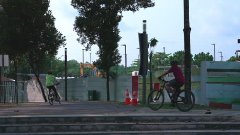 Cyclists-cycling-in-slow-motion-at-Punggol-Promenade-Park,-Singapore