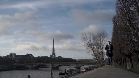 Man-walking-on-bridge-side-in-Eiffel-tower-background