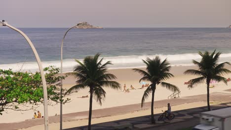 Vista-Aérea-De-Personas-Descansando-En-La-Playa-De-Arena-De-Copacabana-Y-Alcanzando-Olas-Del-Océano-Durante-El-Día-Soleado---Río,-Brasil