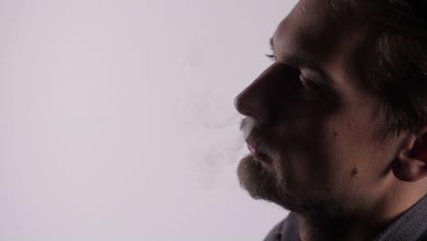 Nahaufnahme-Eines-Mannes,-Der-Vape-Rauch-Durch-Seine-Nasenlöcher-Ausatmet-Und-Zwei-Rauchströme-Erzeugt