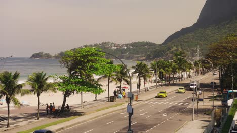 Wide-shot-showing-traffic-on-road-in-front-of-Copacabana-Beach-and-Atlantic-Ocean-in-Brazil