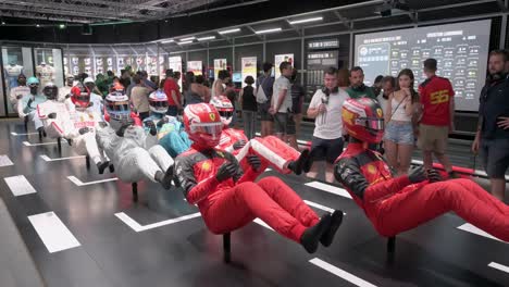 Visitors-look-at-mannequins-dressed-in-racing-suits-highlighting-the-evolution-of-the-F1-sport-and-safety-through-time-during-the-world's-first-official-Formula-1-exhibition
