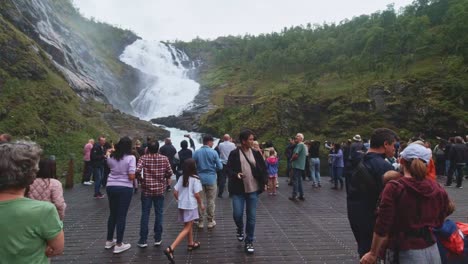 Touristen-Versammeln-Sich-Zu-Einer-Mythologischen-Geschichte-Mit-Der-Dame-In-Rot,-Die-Am-Kjosfossen-Wasserfall-In-Norwegen-Tanzt