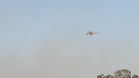 'Elvis'-firefighting-helicopter-disappearing-into-the-smoke-as-it-responds-to-a-rural-bushfire