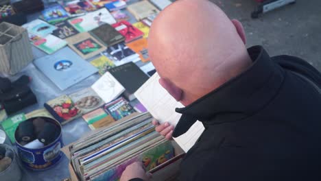 Bold-man-picking-vinyl-in-bazaar